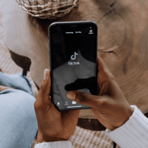 A person holds their smartphone, with the tiktok loading screen visible